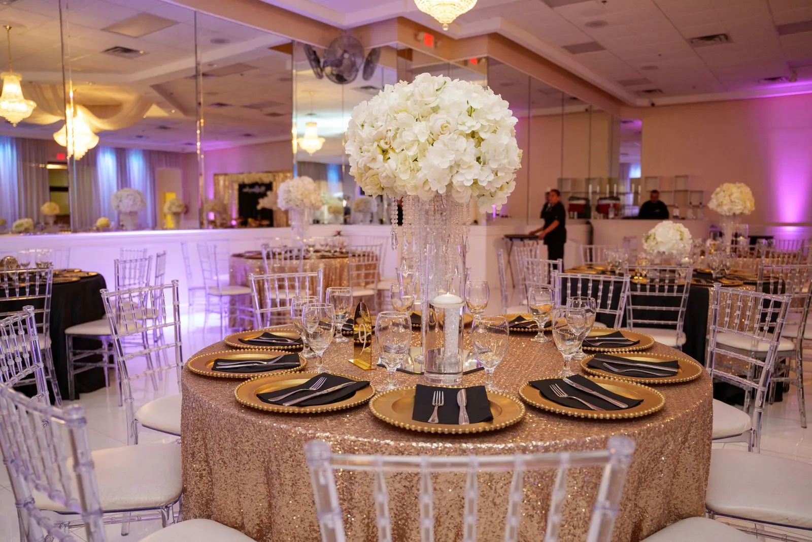A round reception table with a white floral centerpiece in the Luxor Banquet Hall ballroom