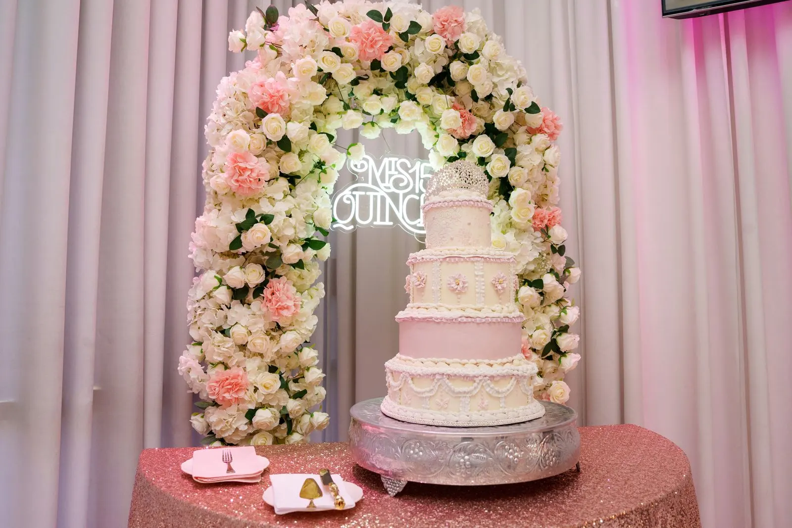 A tiered pink quinceañera cake topped with a tiara at Luxor Banquet Hall